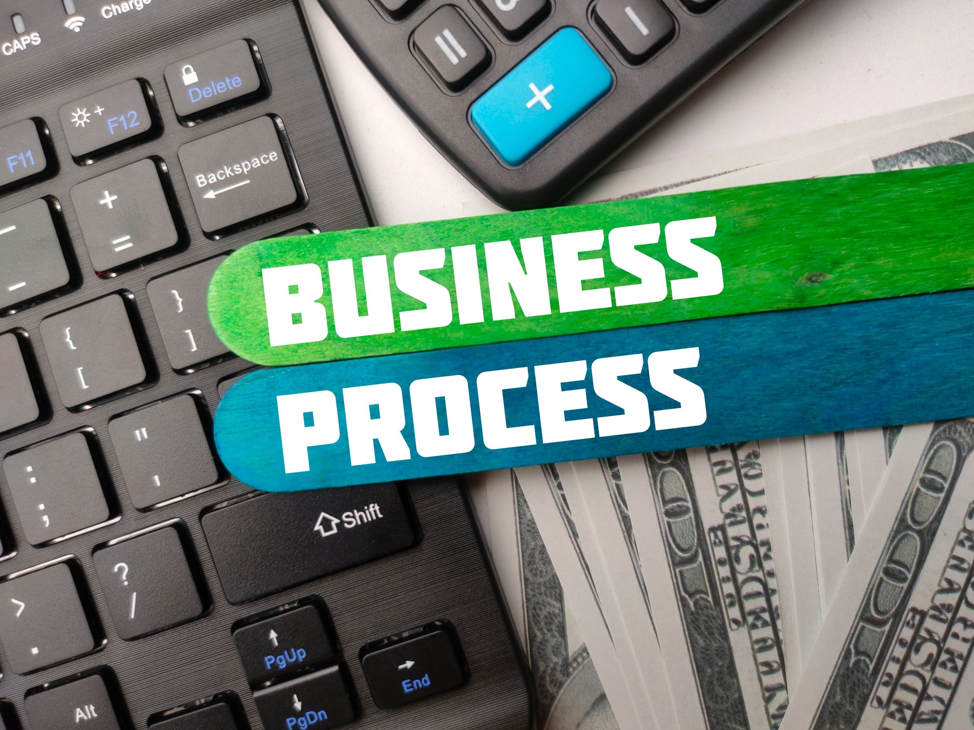 Teclado, calculadora y billetes con la palabra BUSINESS PROCESS