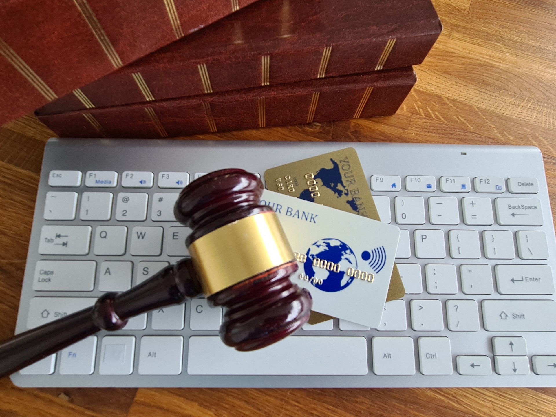 Se coloca un martillo en el teclado de una computadora junto a varias tarjetas de crédito